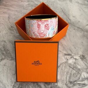 Hermès printed enamel bangle, “Act III, Scene I, La Vie” in orange. Never worn.